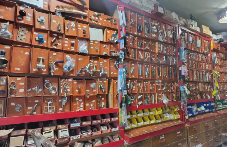 Imagem de armários com vários objetos vendidos numa drogaria, desde torneiras, parafusos, ferragens, ferramentas diversas.
